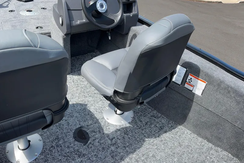 Slide: The Image of 2026 Tracker Super Guide V-16 SC boat interior with gray seating and steering console. - 2