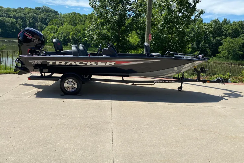 The Image of 2026 Tracker Pro Team 190 boat on trailer, parked near a scenic lake. - 0
