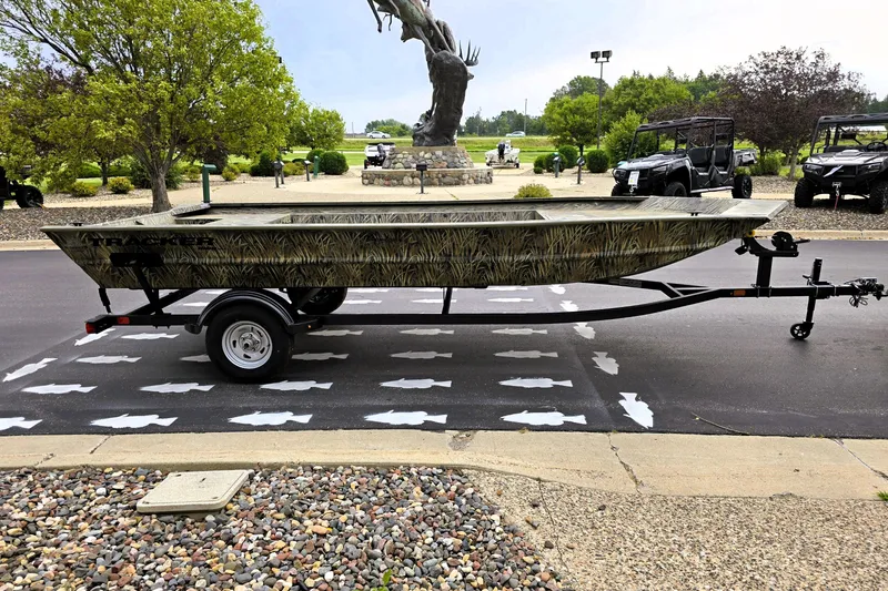 Slide: The Image of 2026 Tracker GRIZZLY 1860 Utility boat on trailer, parked outdoors. - 5