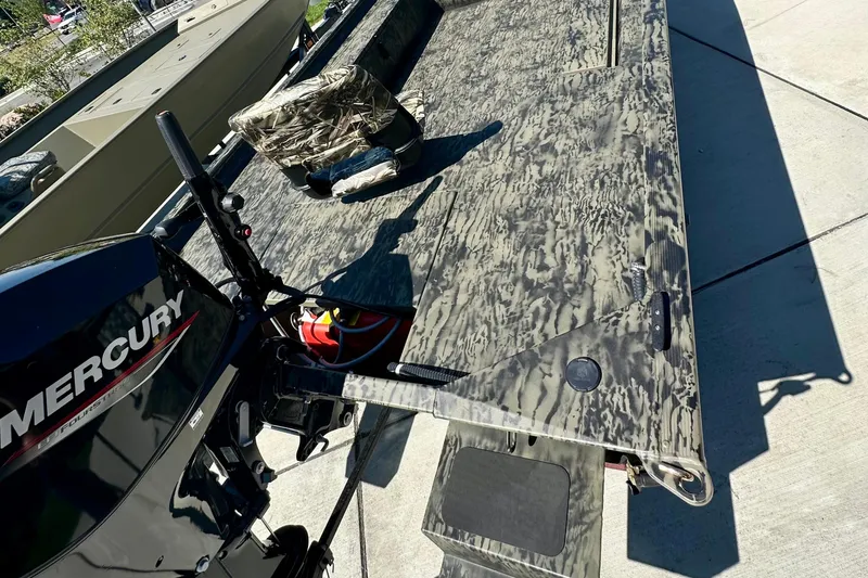 Slide: The Image of 2026 Tracker Grizzly 1654 T Sportsman boat with camo design and Mercury outboard motor. - 2