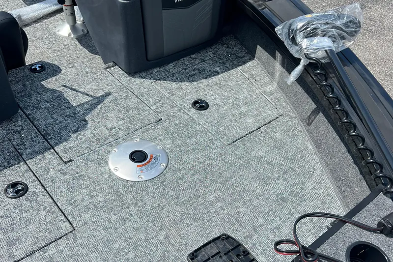 Slide: The Image of 2026 Tracker Targa V-18 Combo boat interior with gray carpet and storage compartments. - 7