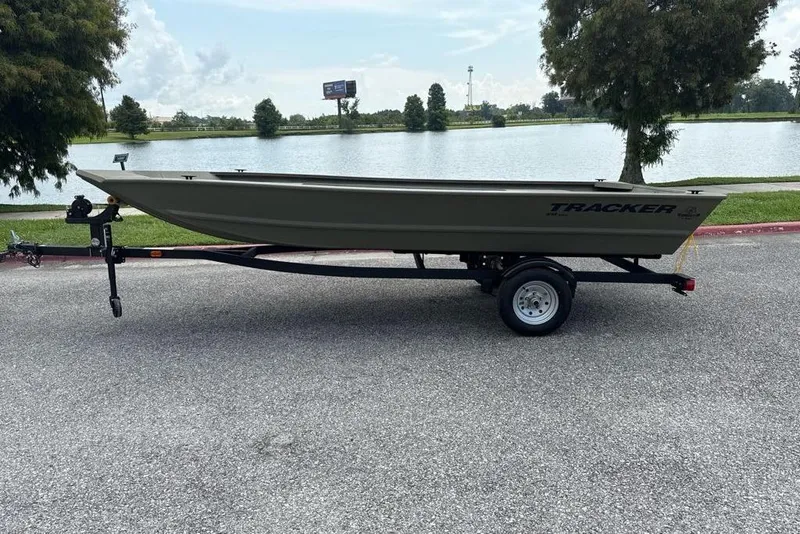 The Image of 2026 Tracker Grizzly 1648 Utility boat on trailer by a lake. - 0