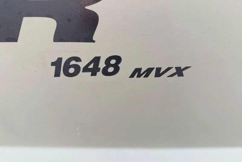 Slide: The Image of Tracker Grizzly 1648 MVX Utility 2026 model logo on a light background. - 2