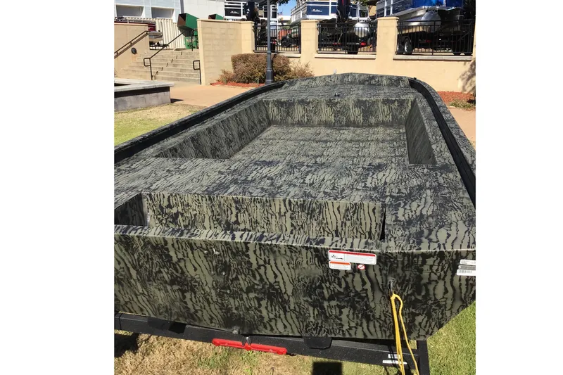 Slide: The Image of 2026 Tracker Grizzly 1860 Utility boat with camouflage design on display outdoors. - 19