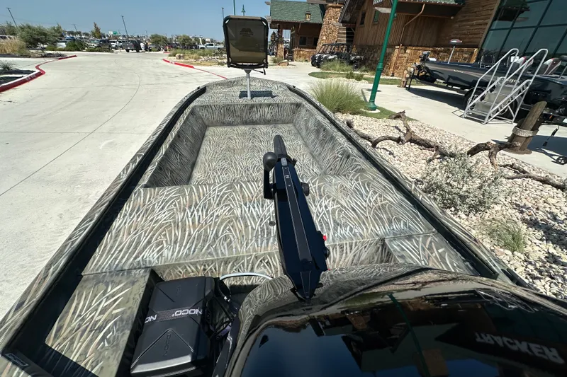 Slide: The Image of 2026 Tracker Grizzly 1648 Utility boat with camouflage interior, parked outdoors. - 18
