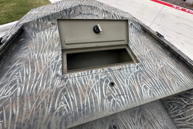Slide: The Image of 2026 Tracker Grizzly 1648 Utility boat with open storage compartment, camo pattern design. - 14