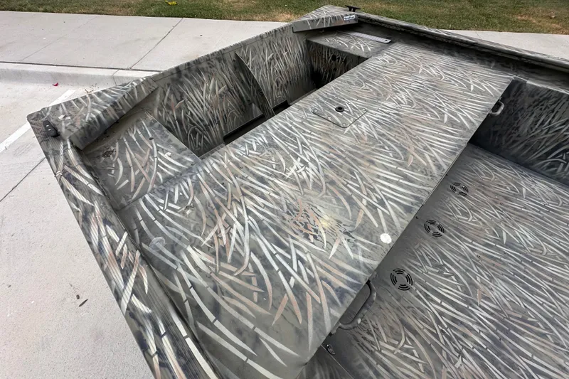 Slide: The Image of 2026 Tracker Grizzly 1648 Utility boat with camouflage pattern on concrete surface. - 15