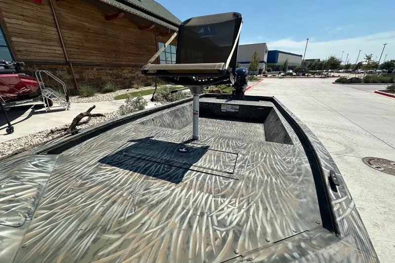 Slide: The Image of 2026 Tracker Grizzly 1648 Utility boat with camouflage design, parked outdoors. - 17