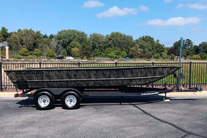 The Image of 2026 Tracker Grizzly 2072 Utility boat on trailer, parked outdoors with trees in background. - 0
