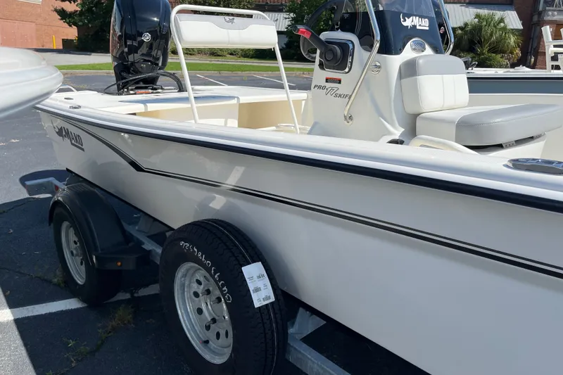 Slide: The Image of 2026 Mako Pro Skiff 17 CC boat on trailer, parked outdoors. - 2