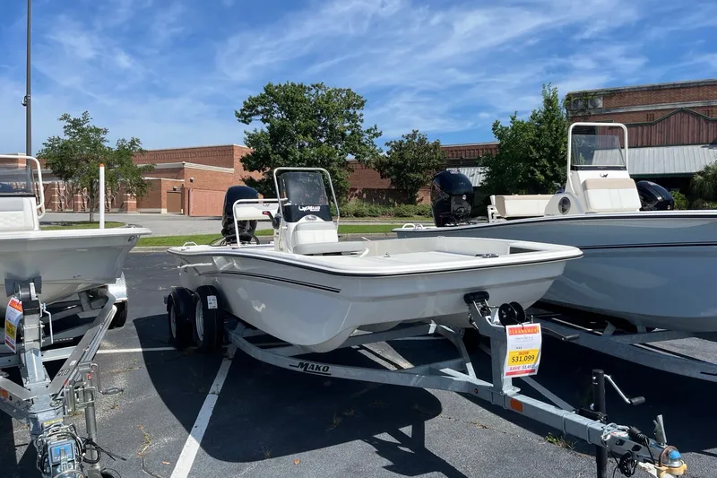 The Image of 2026 Mako Pro Skiff 17 CC boat on trailer in parking lot, sunny day. - 0
