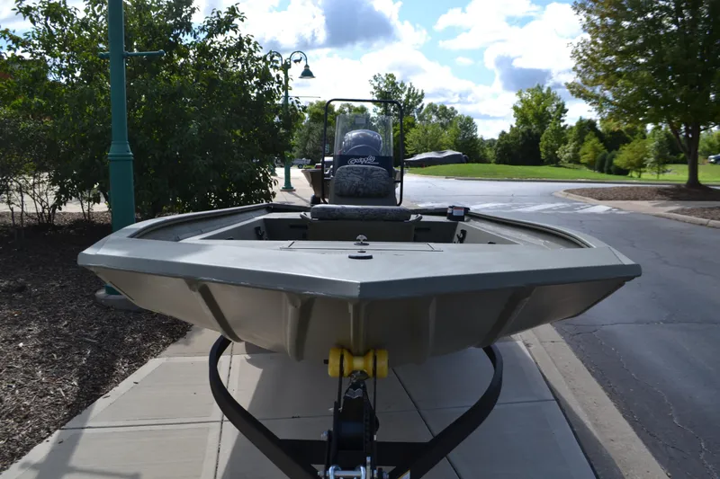 Slide: The Image of 2026 Tracker Grizzly 1860 CC boat on trailer, parked on a sunny street. - 2