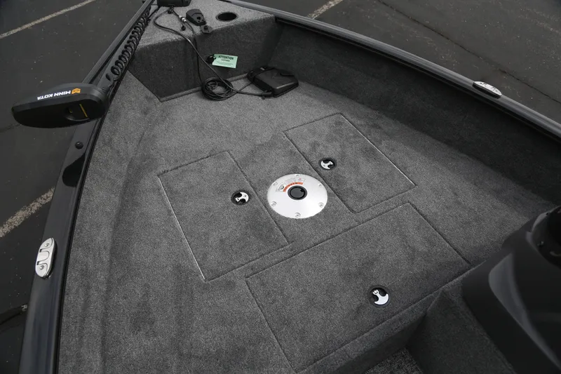 Slide: The Image of 2026 Tracker Super Guide V-16 SC boat interior with carpeted deck and storage compartments. - 2