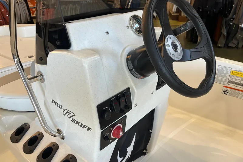 Slide: The Image of 2026 Mako Pro Skiff 17 CC boat console with steering wheel and controls. - 19