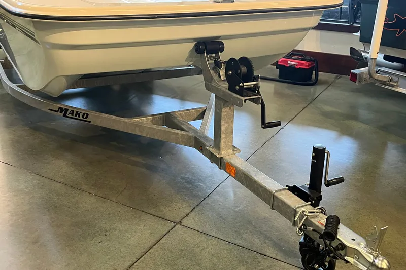 Slide: The Image of 2026 Mako Pro Skiff 17 CC boat on trailer in showroom setting. - 24