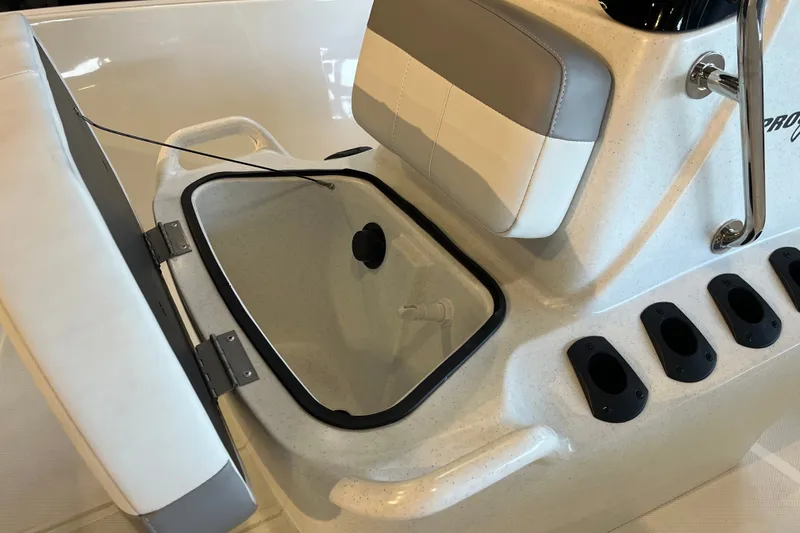 Slide: The Image of 2026 Mako Pro Skiff 17 CC boat interior with open storage compartment and rod holders. - 16