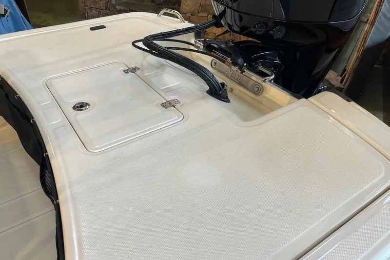 Slide: The Image of 2026 Mako Pro Skiff 17 CC boat deck with storage compartment and motor. - 20