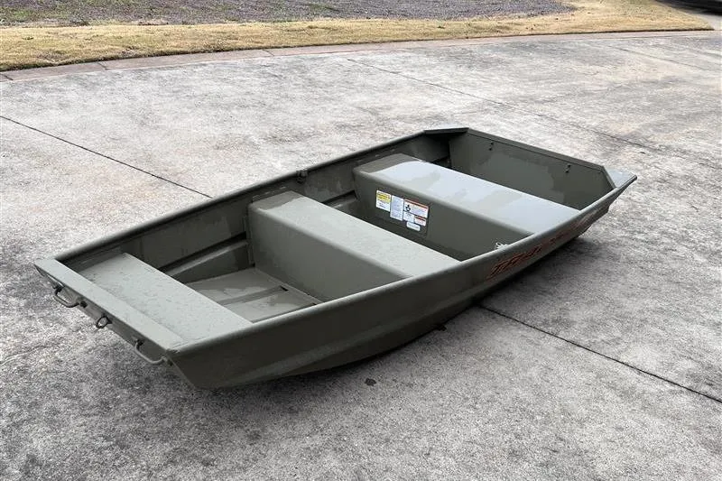 Slide: The Image of 2026 Tracker Grizzly 10 Jon boat on concrete surface, showcasing its sturdy design. - 2