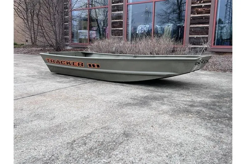 Slide: The Image of 2026 Tracker Grizzly 10 Jon boat on concrete near building. - 6