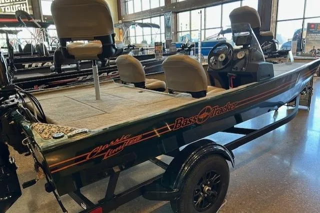 The Image of 2026 Tracker Bass Tracker Classic Limited boat in showroom, featuring seating and steering console. - 0