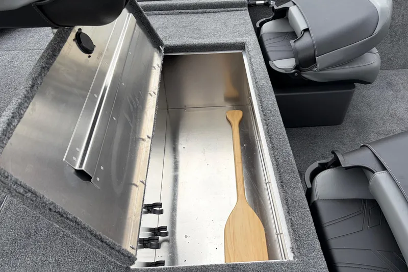 Slide: The Image of 2026 Tracker Bass Tracker Classic XL boat storage compartment with wooden paddle. - 64
