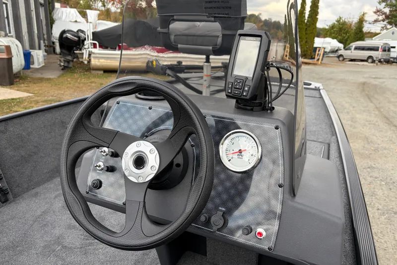 Slide: The Image of 2026 Tracker Bass Tracker Classic XL dashboard with steering wheel and GPS device. - 78