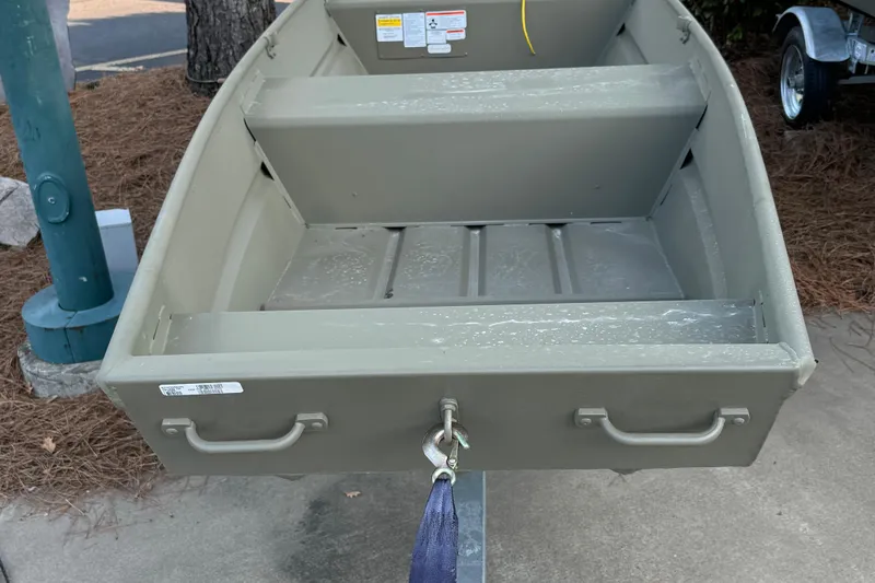 Slide: The Image of 2026 Tracker Grizzly 14 Jon boat on trailer, parked outdoors. - 2