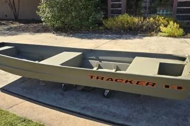 Slide: The Image of 2026 Tracker Grizzly 14 Jon boat on concrete driveway, outdoor setting. - 4