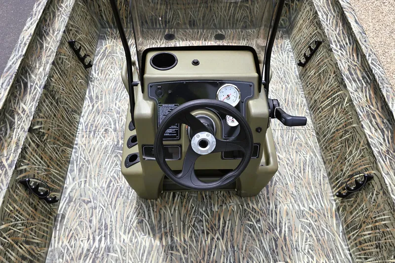 Slide: The Image of 2026 Tracker Grizzly 1860 CC boat interior with camouflage design and steering console. - 3