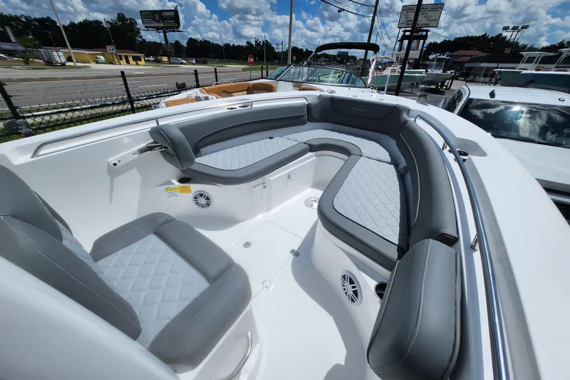 Slide: The Image of 2026 NauticStar 252 Legacy boat interior with gray cushioned seating under a blue sky. - 10