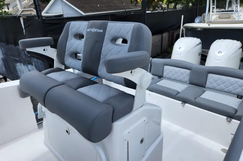 Slide: The Image of 2026 NauticStar 252 Legacy boat interior with gray cushioned seating and dual outboard engines. - 5