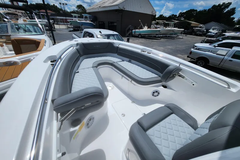Slide: The Image of 2026 NauticStar 252 Legacy boat with luxurious seating and sleek design in a marina setting. - 9
