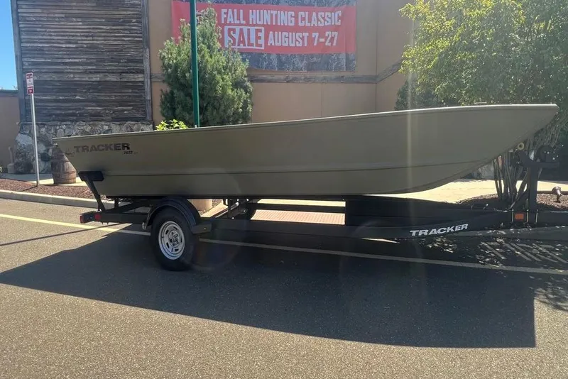 The Image of 2026 Tracker GRIZZLY 2072 Utility boat on trailer, parked near sale sign. - 0