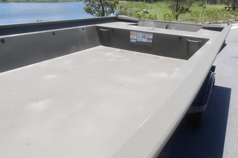 Slide: The Image of 2026 Tracker Grizzly 1860 Utility boat interior, spacious deck near a serene lake. - 10