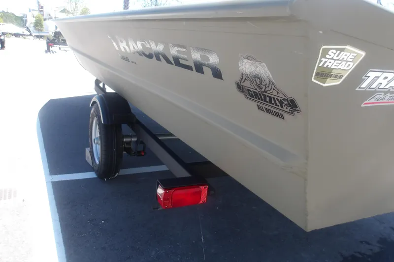 Slide: The Image of 2026 Tracker Grizzly 1860 Utility boat on trailer, featuring Sure Tread and Grizzly decals. - 19