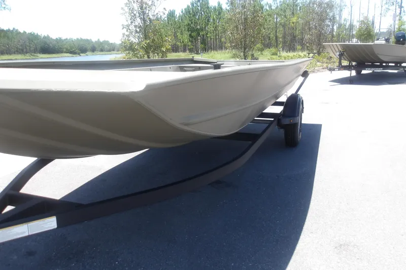 Slide: The Image of 2026 Tracker Grizzly 1860 Utility boat on trailer, parked near a scenic lake. - 9