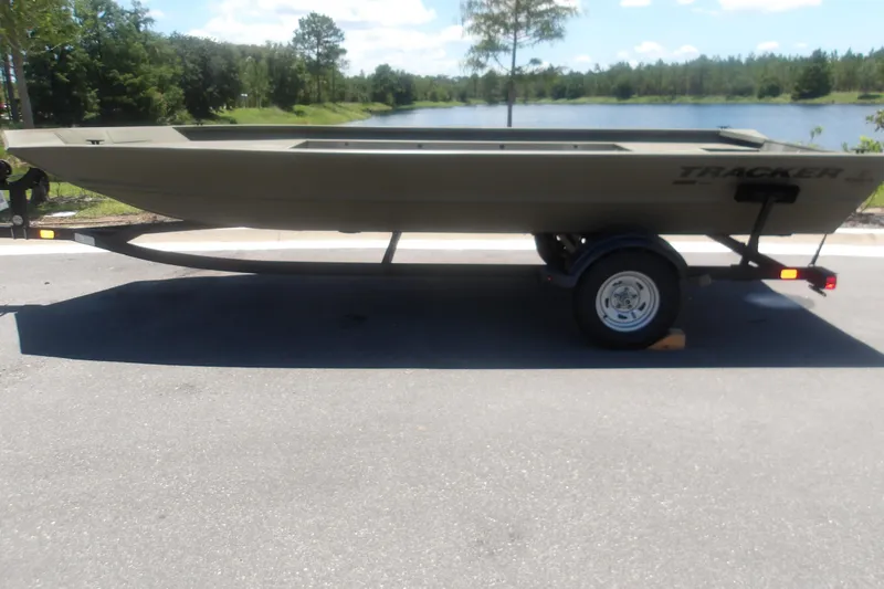 Slide: The Image of 2026 Tracker Grizzly 1860 Utility boat on trailer by a scenic lake. - 12