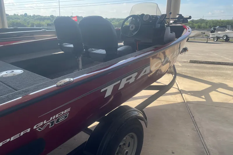 Slide: The Image of 2026 Tracker Super Guide V-16 SC boat on trailer, side view in sunlight. - 3