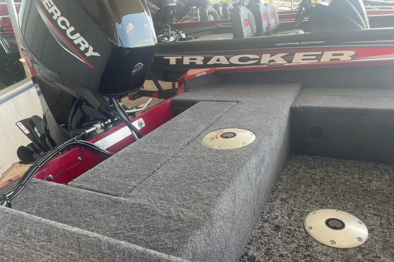 Slide: The Image of 2026 Tracker Super Guide V-16 SC boat interior with Mercury engine, gray carpeted deck. - 6