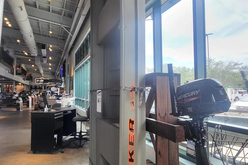 The Image of Indoor showroom displaying 2026 Tracker Grizzly 14 Jon boat with Mercury engine. - 0