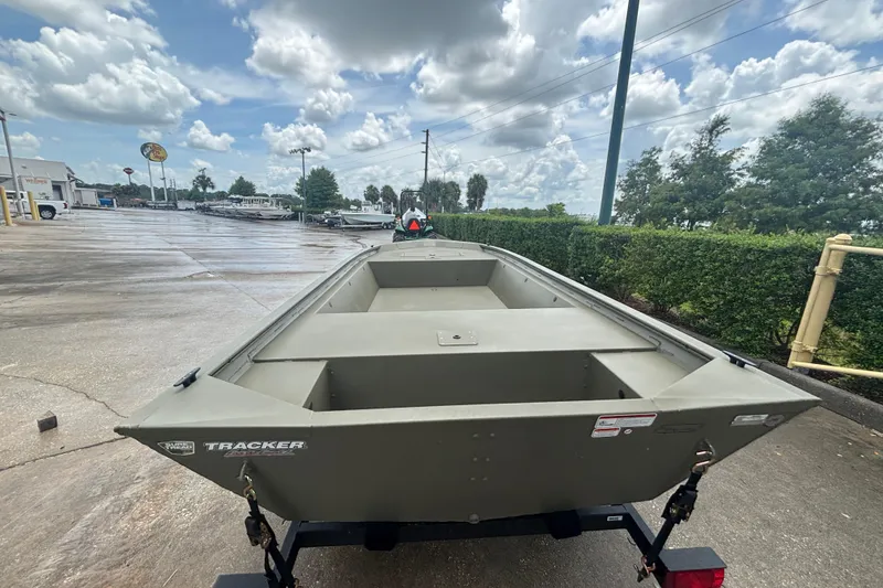 Slide: The Image of 2026 Tracker Grizzly 1648 Utility boat on trailer, outdoor dealership setting. - 2