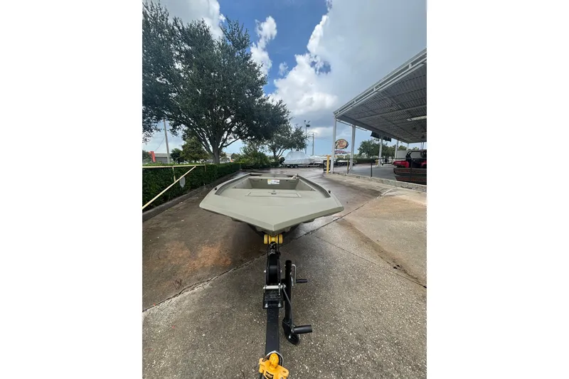 Slide: The Image of 2026 Tracker Grizzly 1648 Utility boat on trailer, parked outdoors under cloudy sky. - 3