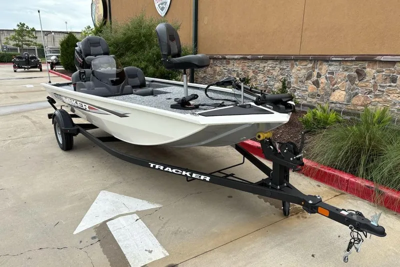 Slide: The Image of 2026 Tracker Pro 170 boat on trailer, parked outdoors near stone wall. - 2