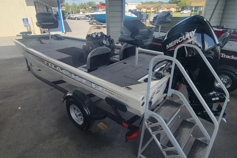 Slide: The Image of 2026 Tracker Pro 170 boat with Mercury engine in showroom setting. - 2
