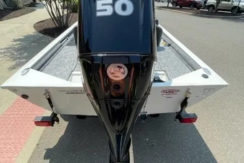 Slide: The Image of 2026 Tracker Pro 170 boat with a 50 HP outboard motor, parked on a street. - 2