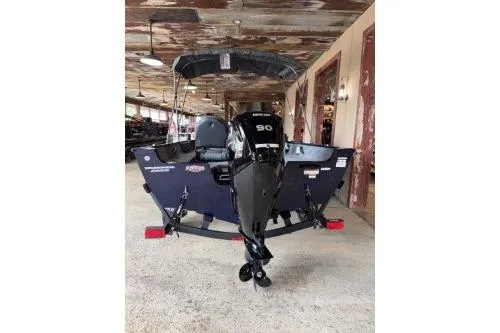 Slide: The Image of 2026 Tracker Pro Guide V-16 SC boat with Mercury 90 engine, parked indoors. - 7