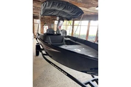 The Image of 2026 Tracker Pro Guide V-16 SC boat with canopy in a wooden boathouse. - 0