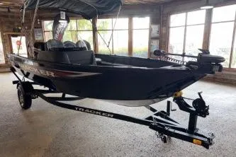 Slide: The Image of 2026 Tracker Pro Guide V-16 SC boat on trailer in showroom. - 5