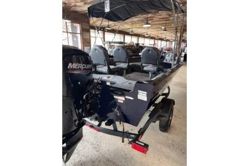Slide: The Image of 2026 Tracker Pro Guide V-16 SC boat with Mercury engine in a showroom. - 2