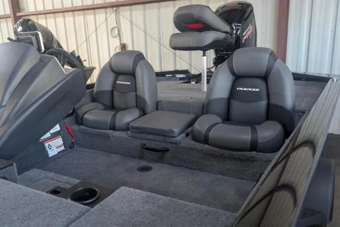 Slide: The Image of 2026 Tracker Pro Team 190 boat interior with cushioned seating and motor in a storage area. - 6